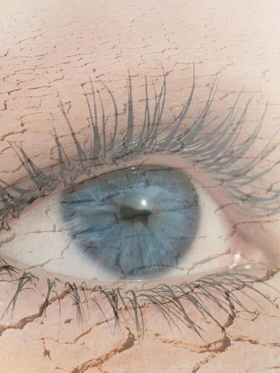 Eye Health: Double exposure of human eye in dry land on the background.