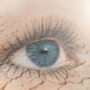 Eye Health: Double exposure of human eye in dry land on the background.
