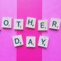 Gifts Your Mom Will Love: Mother's Day spelled out in Scrabble Tiles against a pink striped background
