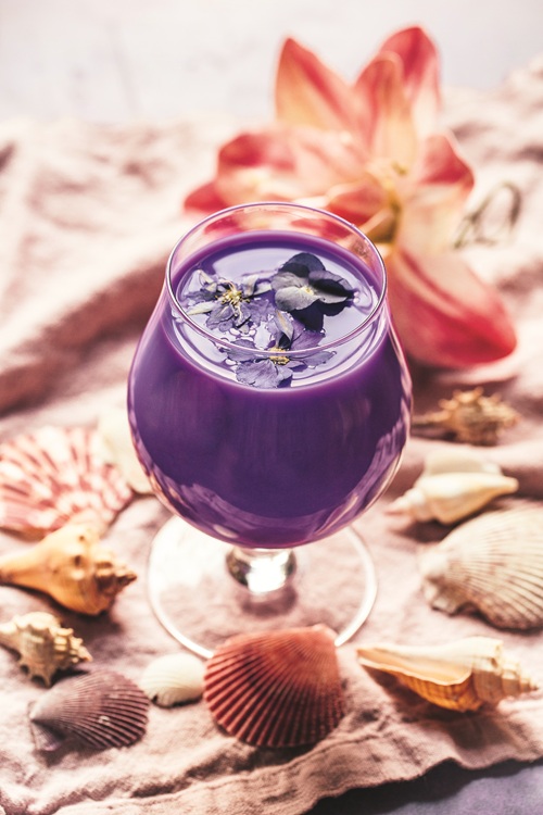 Beach Cocktails: Spirit of Aloha Cocktail: Purple drink in a stemmed cocktail glass