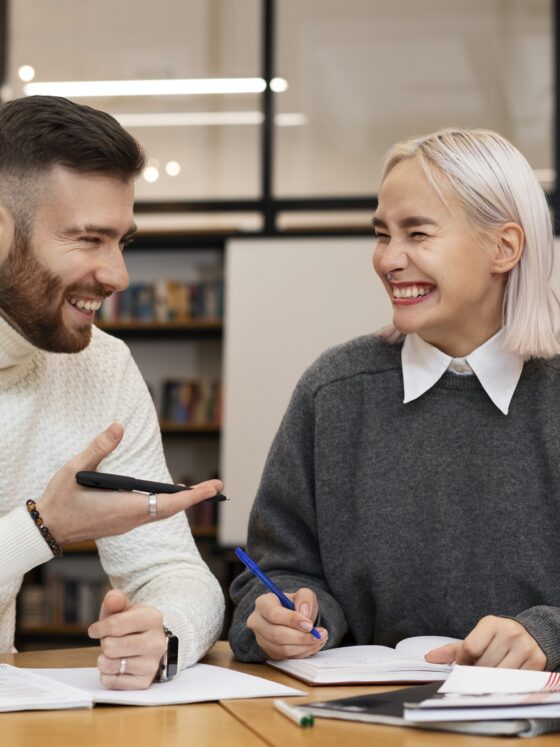 Tutors in Toronto: Two friends laughing as they are studying together