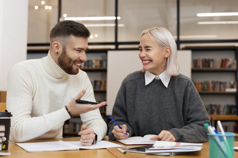 Tutors in Toronto: Two friends laughing as they are studying together
