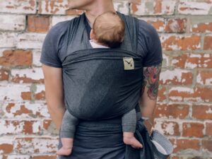 New Parent: Father holding newborn baby in a sling