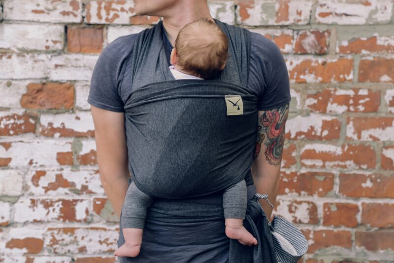 New Parent: Father holding newborn baby in a sling