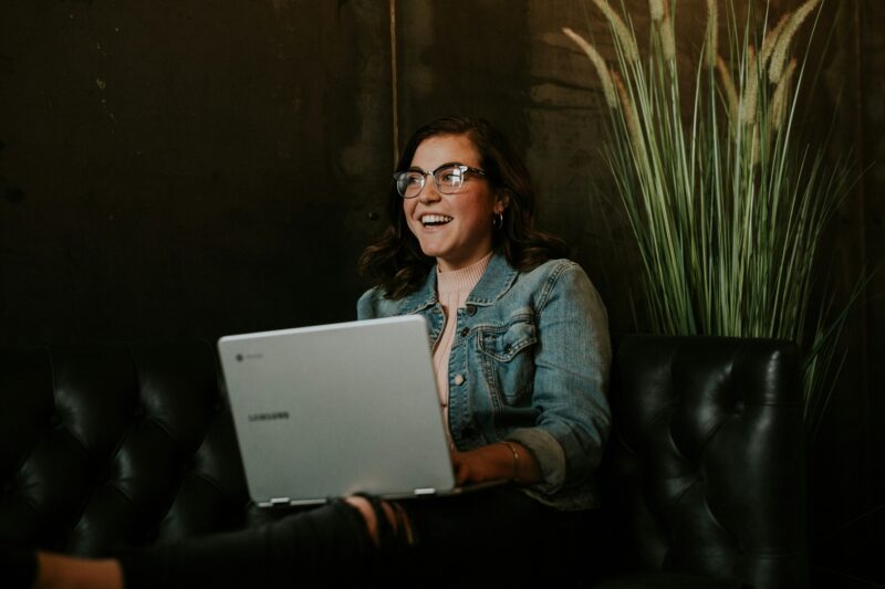 Online Payment: Woman smiling while holding a laptop