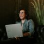 Online Payment: Woman smiling while holding a laptop