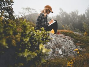 Paper Journaling: Woman in nature writing in a journal