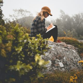 Paper Journaling: Woman in nature writing in a journal