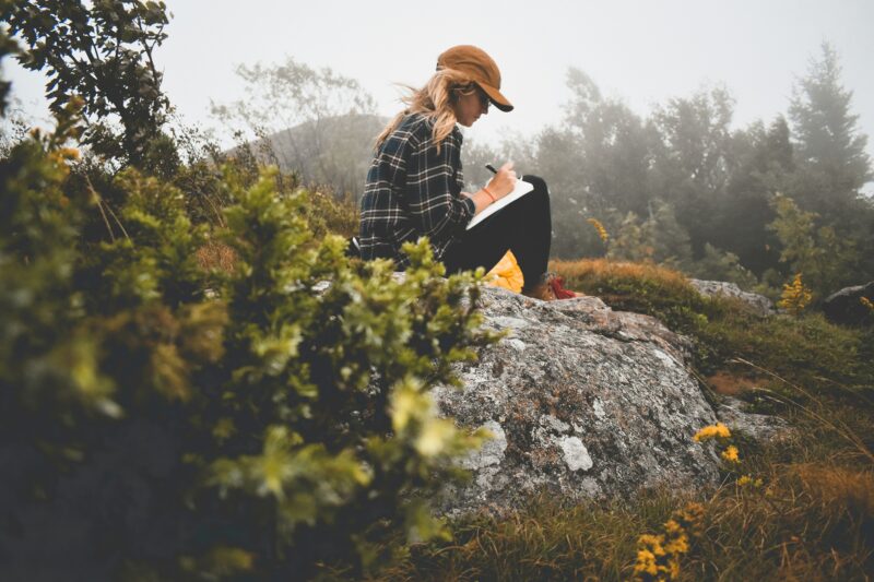 Paper Journaling: Woman in nature writing in a journal