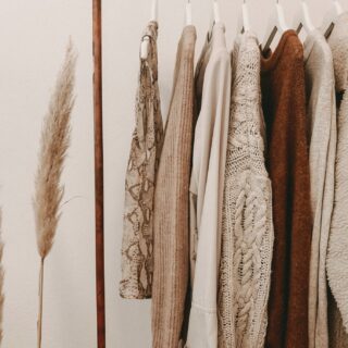 Minimalist Fall Wardrobes: Tops and sweaters hanging on a clothing rack