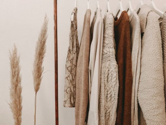 Minimalist Fall Wardrobes: Tops and sweaters hanging on a clothing rack