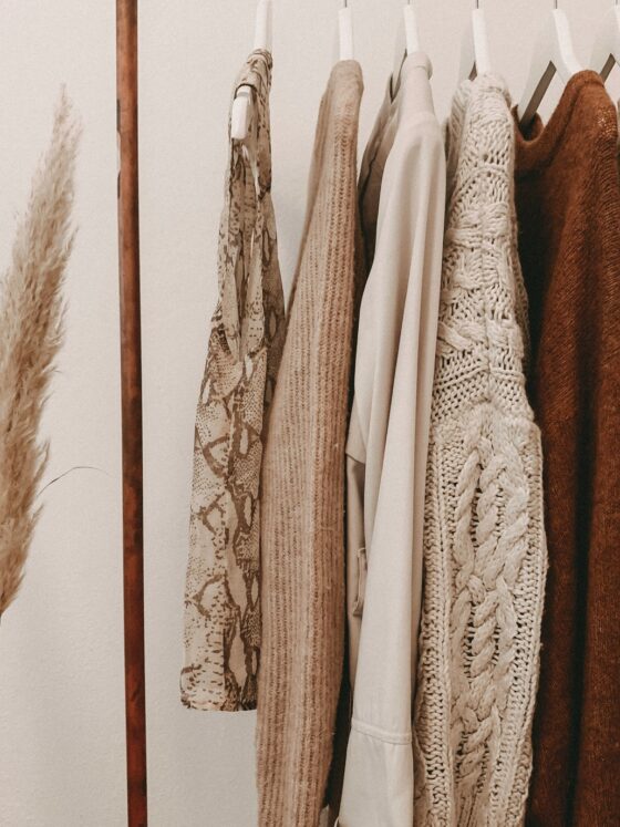 Minimalist Fall Wardrobes: Tops and sweaters hanging on a clothing rack