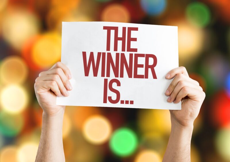 Win Things: The Winner Is... placard with bokeh background