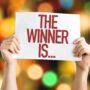 Win Things: The Winner Is... placard with bokeh background