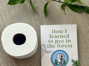 How I Learned to Pee in the Forest : Book with a roll of toilet paper and stem of a green plant