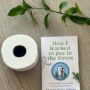 How I Learned to Pee in the Forest : Book with a roll of toilet paper and stem of a green plant