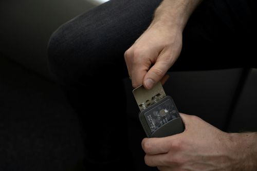 Gifts for your Mother-In-Law: Man holding a cardholder and pulling out a credit card
