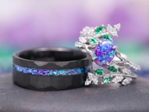 Same Stone: matching nature-inspired couples' wedding ring set from Aquamarise Lavender Opal & Emerald Fairy Leaf collection men's wedding band and woman's ring stacked near each other