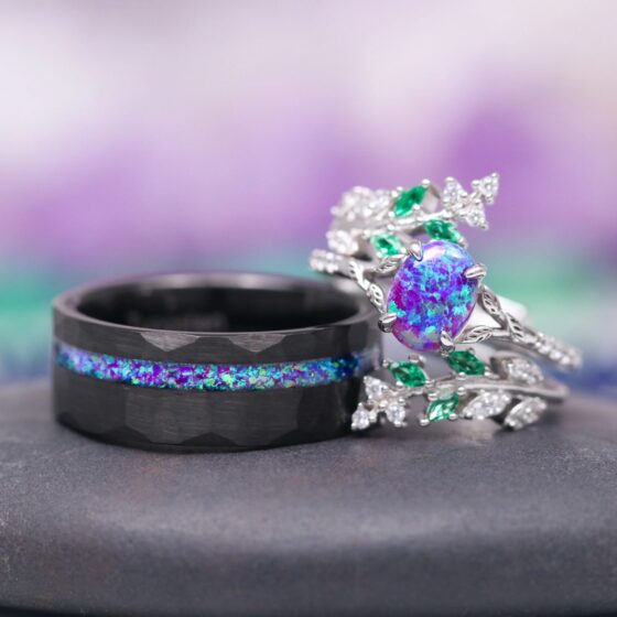Same Stone: matching nature-inspired couples' wedding ring set from Aquamarise Lavender Opal & Emerald Fairy Leaf collection men's wedding band and woman's ring stacked near each other