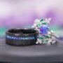 Same Stone: matching nature-inspired couples' wedding ring set from Aquamarise Lavender Opal & Emerald Fairy Leaf collection men's wedding band and woman's ring stacked near each other