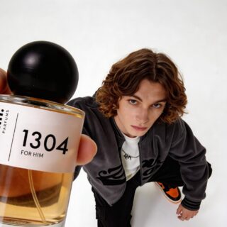 Perfume Dupes: Man with long hair holding a bottle of divain. 1304