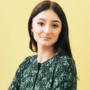 iGaming Expert: Young Woman with long brown hair wearing a green top against a pale yellow background