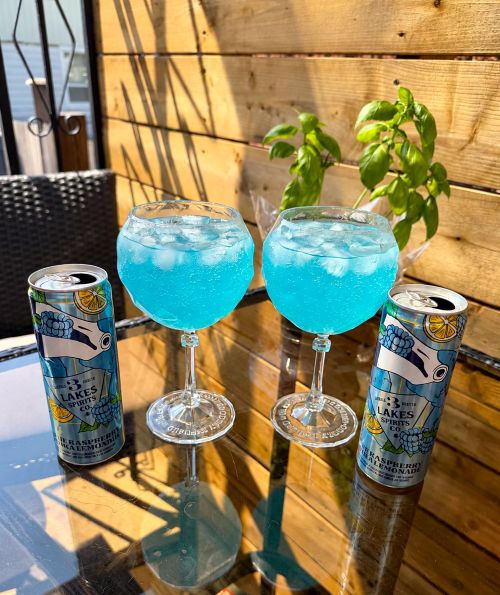 RTDs: 3 Lakes Spirts Raspberry Vodka Lemonade in two oversized glasses with cans beside them