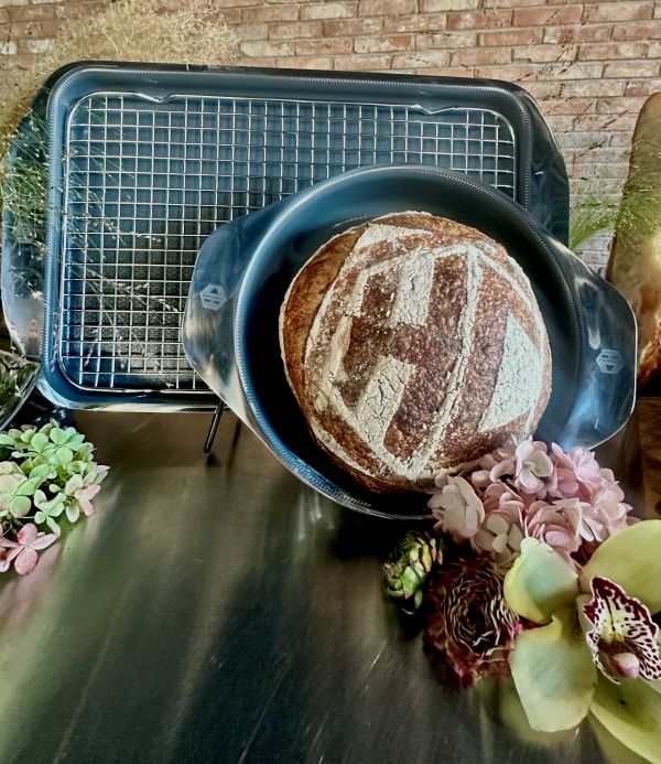 Sourdough: Round bread with Hexclad logo in a baking pan in front of a baking sheet with cooling rack.