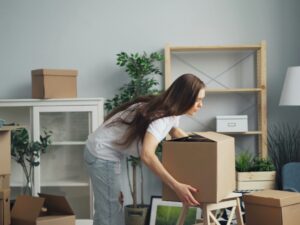 Relocation: Woman packing boxes in a living area