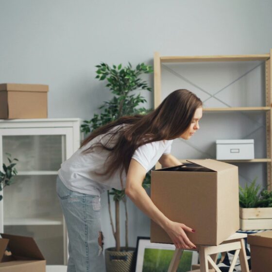 Relocation: Woman packing boxes in a living area