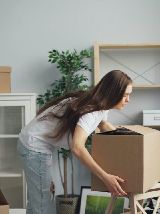 Relocation: Woman packing boxes in a living area