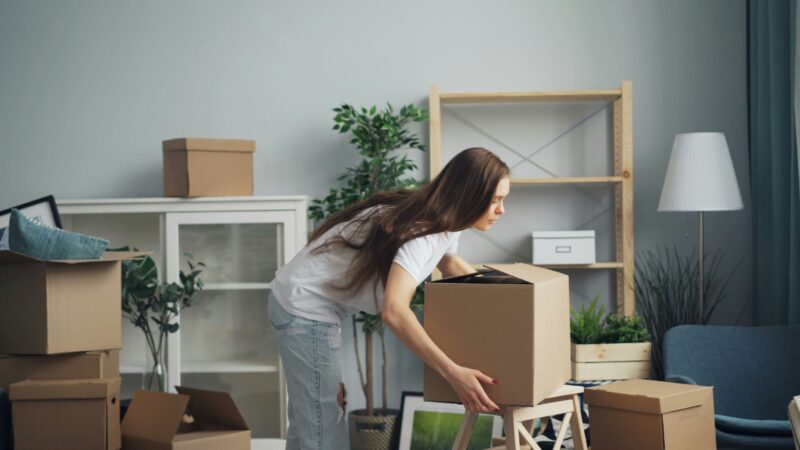 Relocation: Woman packing boxes in a living area