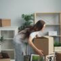 Relocation: Woman packing boxes in a living area