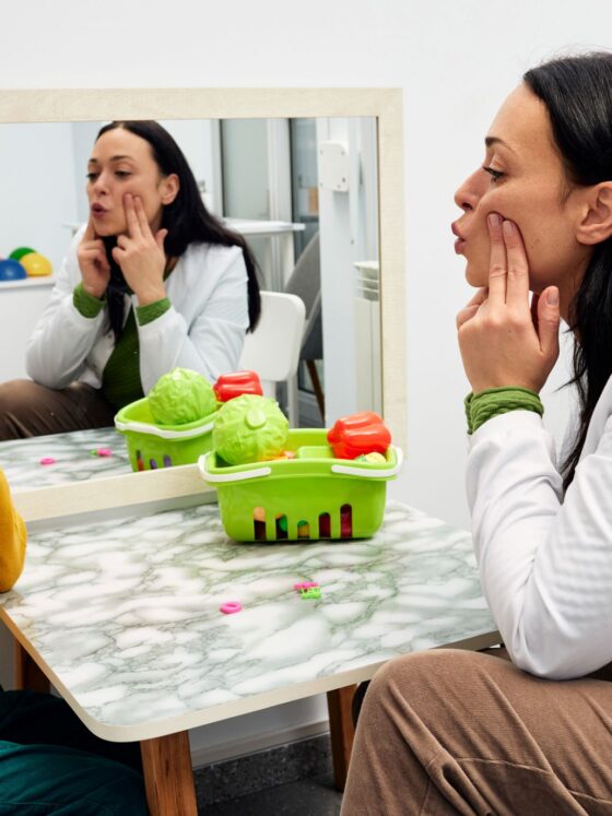 Stutter: female speech pathologist working with a young red-headed boy