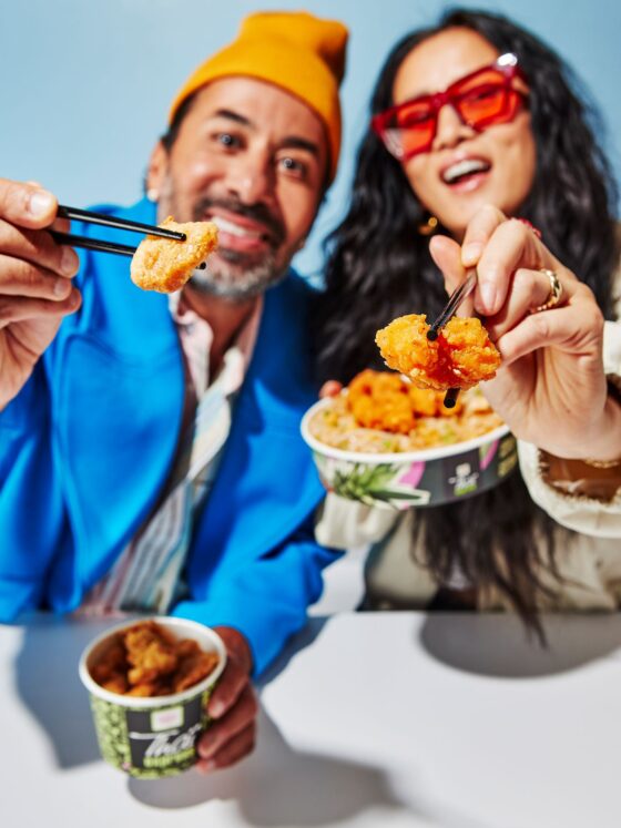 Calamari: Couple holding Thai Express Bowls with food on chopsticks