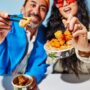 Calamari: Couple holding Thai Express Bowls with food on chopsticks