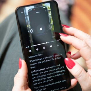 Unlimited Data: Woman Holding her mobile phone - close up of her manicured hands as she looks at a video.