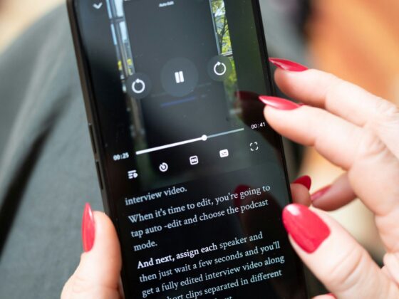Unlimited Data: Woman Holding her mobile phone - close up of her manicured hands as she looks at a video.