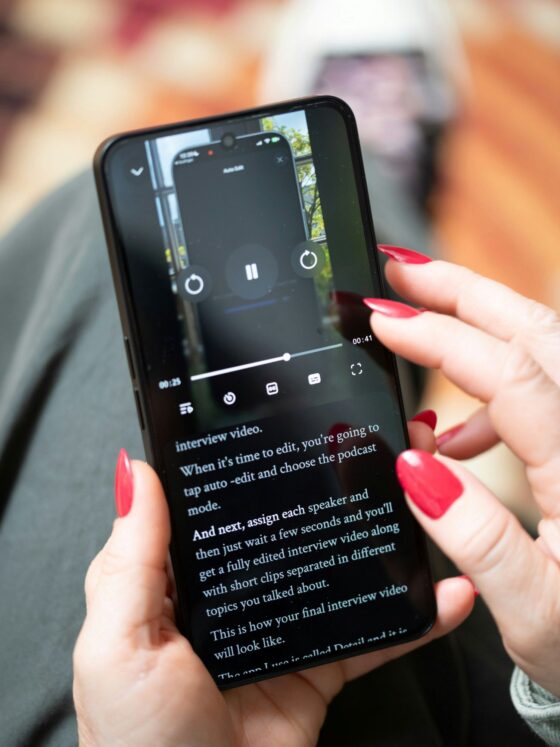 Unlimited Data: Woman Holding her mobile phone - close up of her manicured hands as she looks at a video.