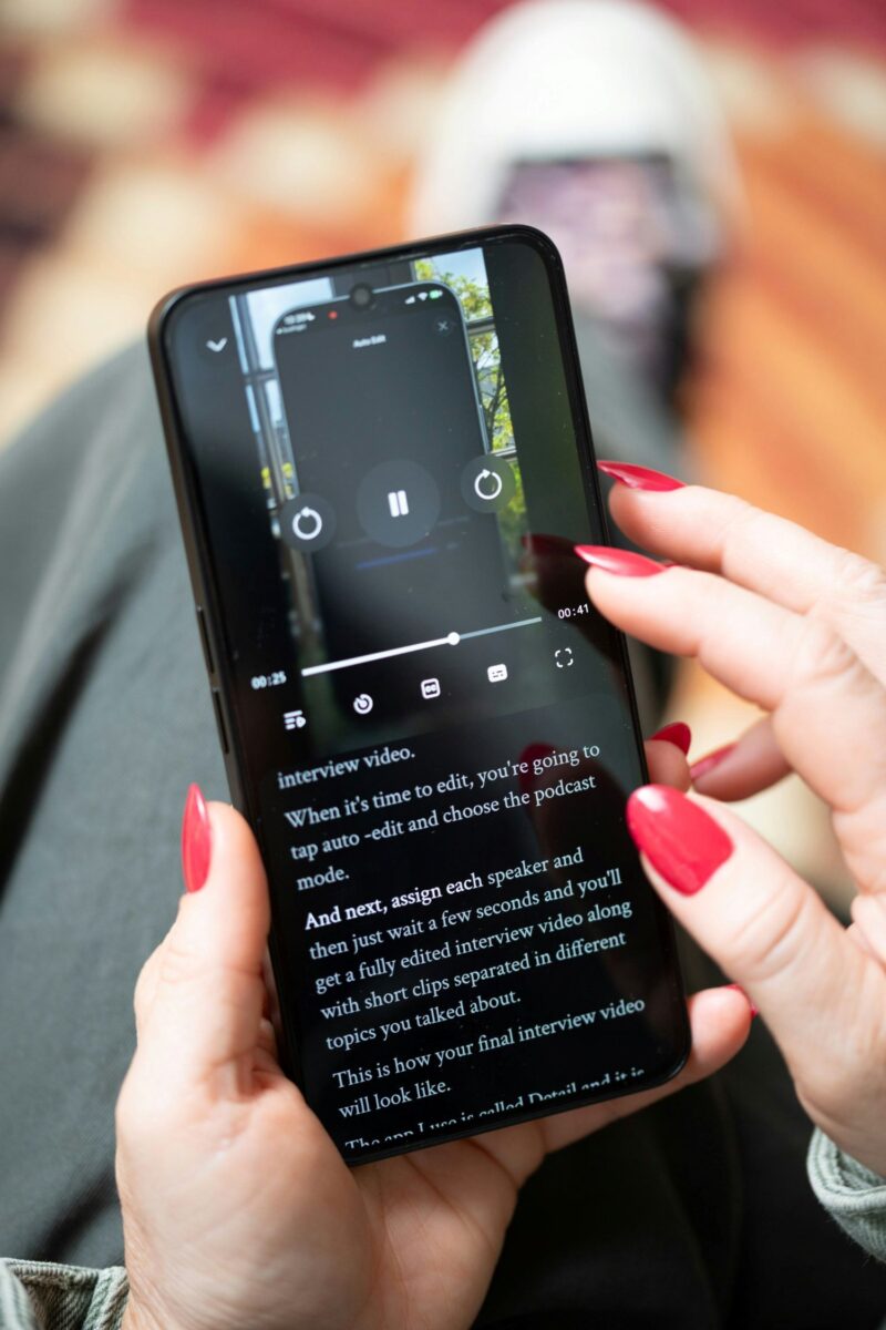 Unlimited Data: Woman Holding her mobile phone - close up of her manicured hands as she looks at a video.