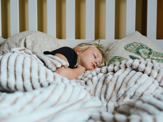 Petite fille qui dort paisiblement dans un lit sous une couverture