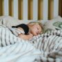 Petite fille qui dort paisiblement dans un lit sous une couverture